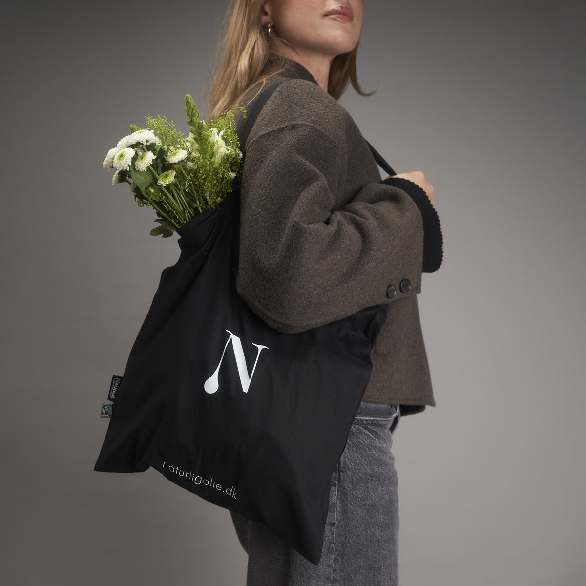 Model med sort tote bag og blomster