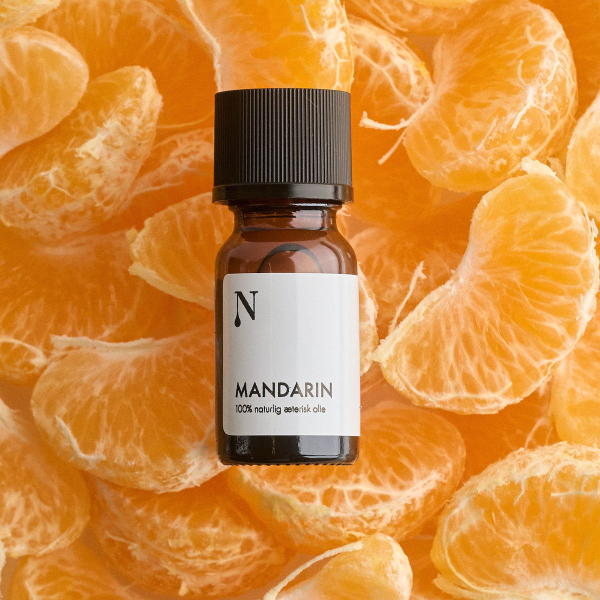Flaske med mandarinolie på mandarinbåde