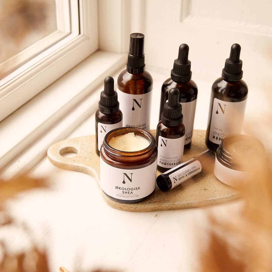Seks Naturligolie-produkter samlet på et keramikfad i en vindueskarm
