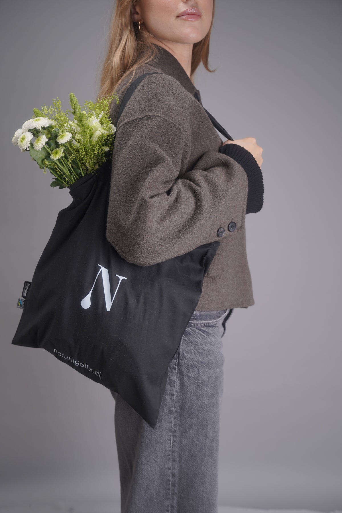 Model med sort tote bag, set fra siden