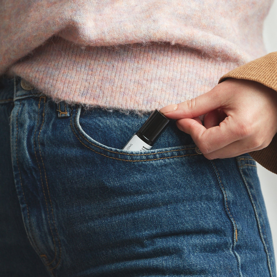 Hånd der lader en negleoliepen glide ned i baglommen på et par jeans