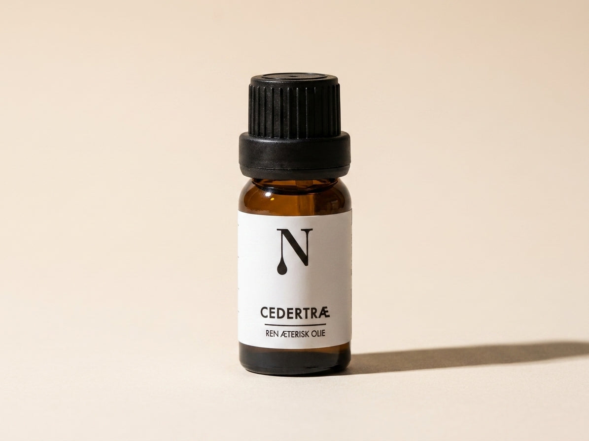 Naturligolie Cedertræolie, 10 ml flaske på cremefarvet bund